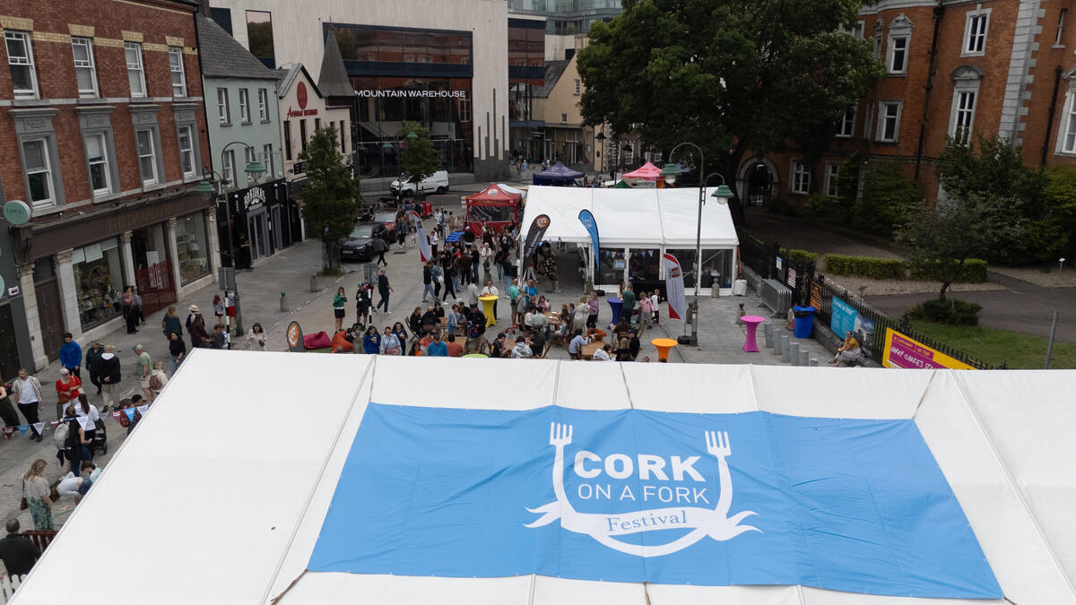 Crowds gathered around the Cork on a Fork Festival marquee in Cork city centre, with the festival logo visible on the tent roof.